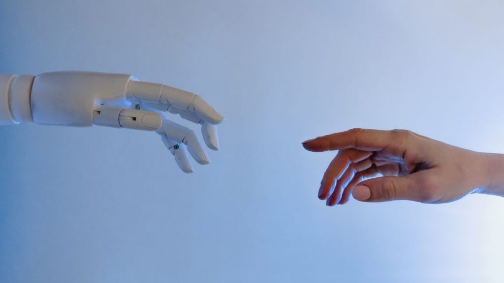 Dłoń robota wyciągnięta w kierunku dłoni człowieka