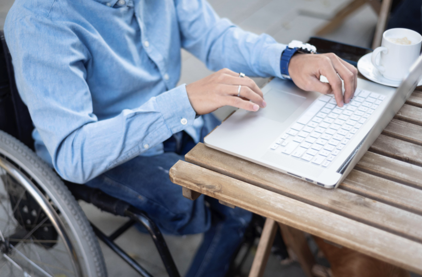 mężczyzna na wózku inwalidzkim pracuje przy laptopie